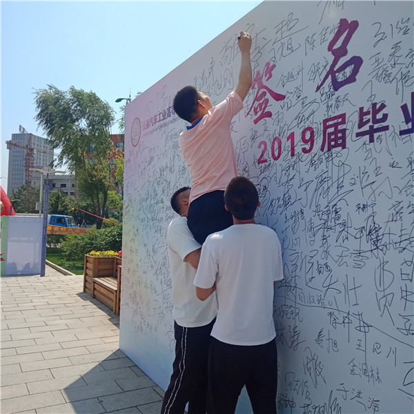 图片 十三毕业生在签名墙上签名.png